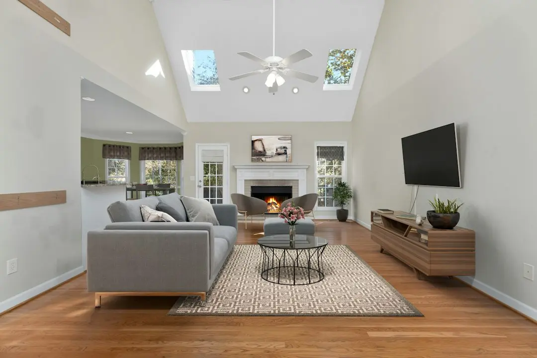 A bright family room with a gray sofa facing a wall-mounted TV, set up for KenoaTV IPTV in the USA