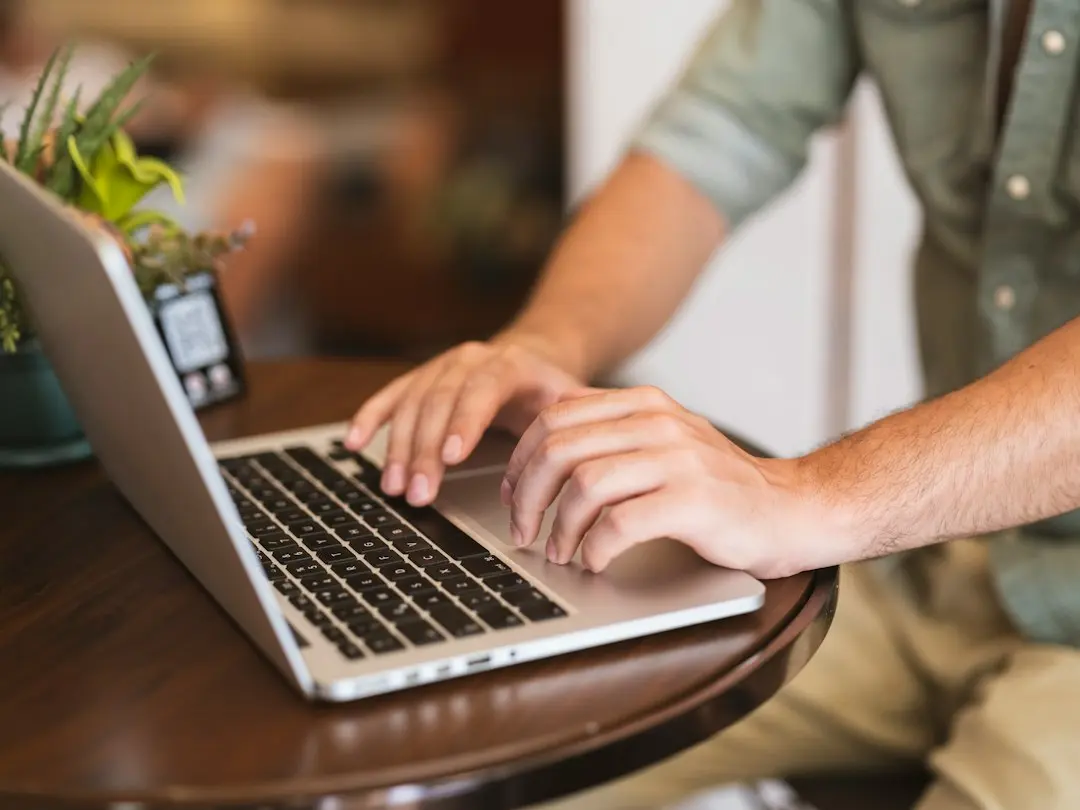 Hands typing on a laptop, entering a KenoaTV M3U playlist or Xtream Codes login
