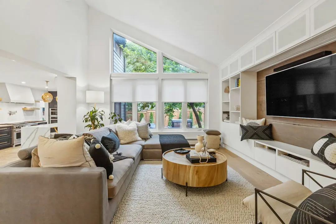 A bright living room with a large wall-mounted TV and a sofa, where KenoaTV IPTV streams over the internet